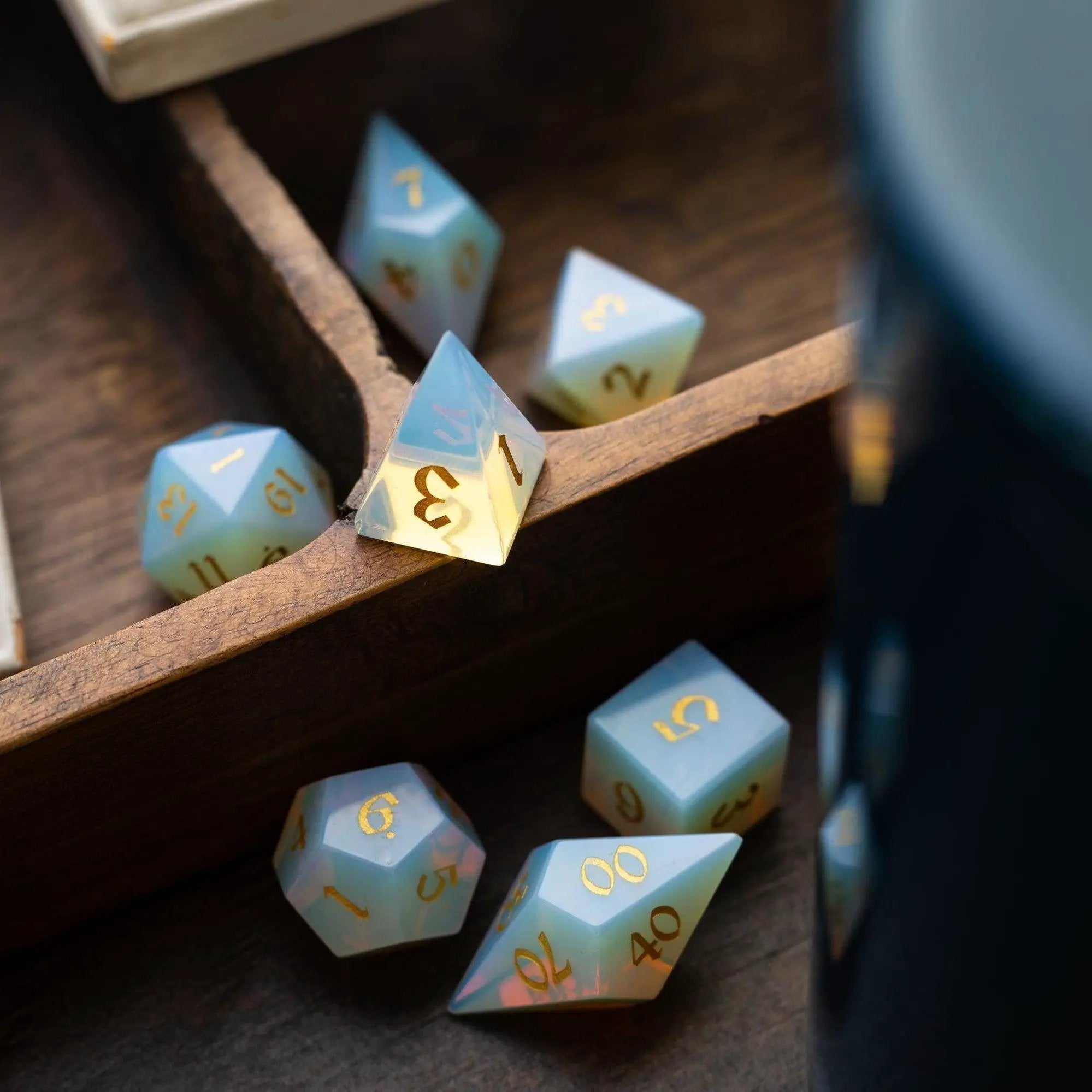 Runic Dice gemstone opalite Elven cut DND dice set featuring transparent, shimmering gemstone dice with intricate Elven-style cut details.