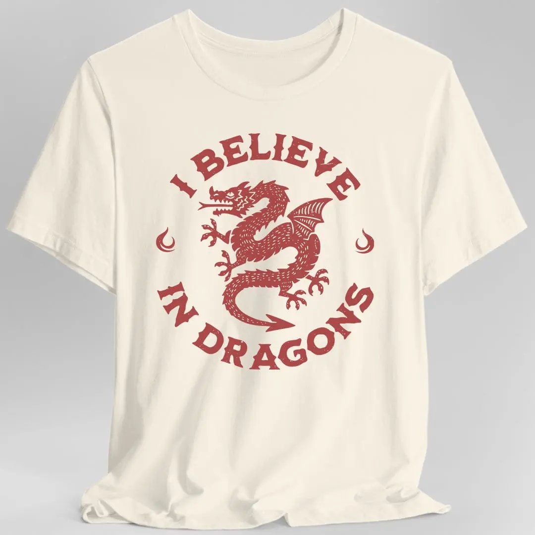 Sunburst RPG I Believe in Dragons T-Shirt featuring a colorful dragon graphic on a natural-colored fabric.