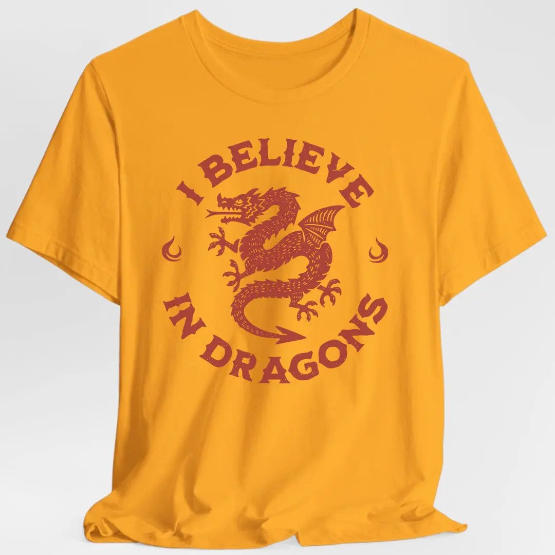 Gold "I Believe in Dragons" T-shirt by Sunburst RPG, featuring a fantasy-themed design on a casual shirt.
