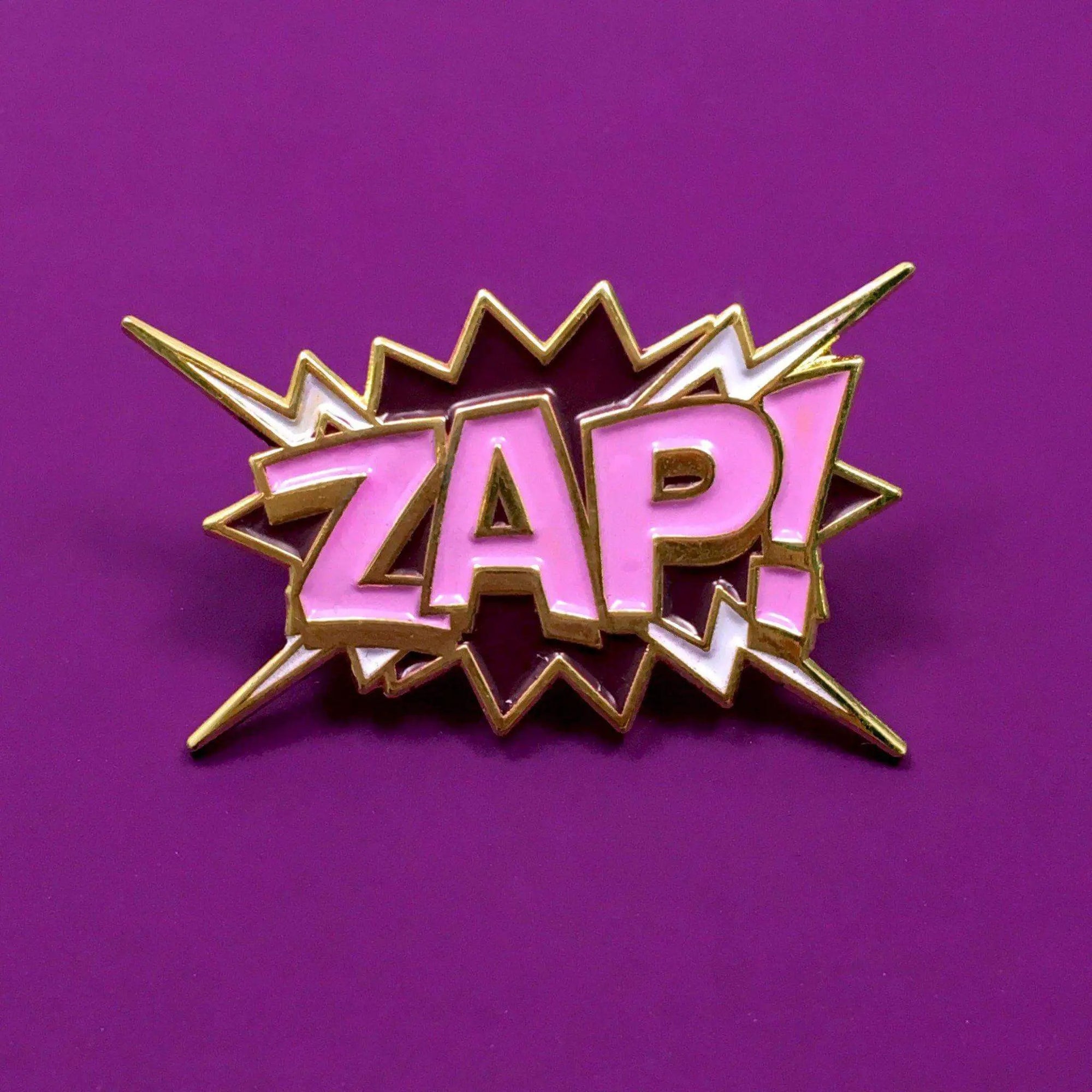 Colorful enamel "ZAP!" pop art pin by Kolorspun featuring a vibrant comic-style design on a metallic pin back.